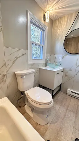 a bathroom with a sink toilet a mirror and tub