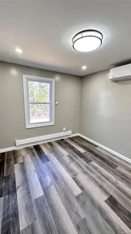a view of a room with wooden floor and a window