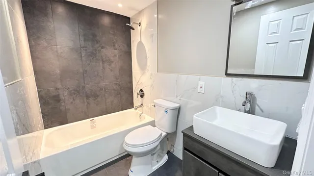 a bathroom with a white toilet sitting next to a bathtub