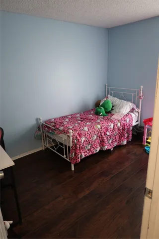 a bedroom with a bed table and a lamp