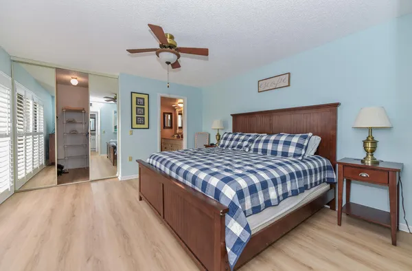 a bedroom with a bed and dresser with mirror