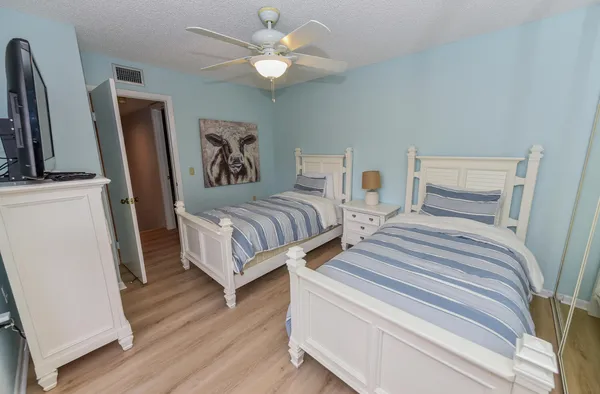 a bedroom with two beds and a chandelier