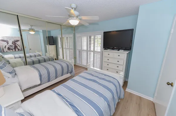 a bedroom with a bed a couch and a flat screen tv