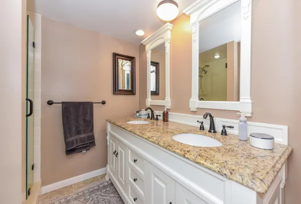 a bathroom with a granite countertop sink and mirror