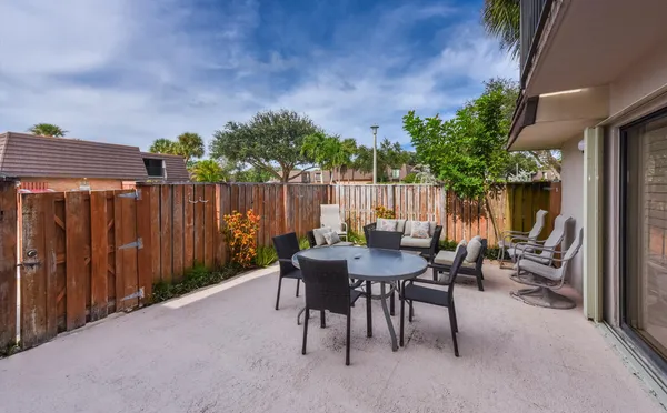 a view of a patio with table and chairs and potted plants
