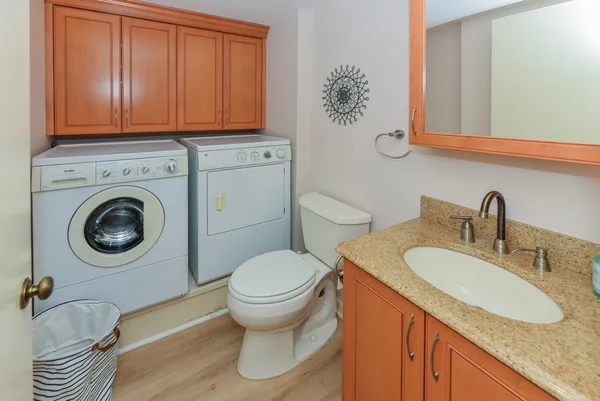 a bathroom with a granite countertop sink and a toilet