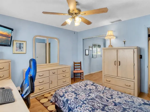 a bedroom with a large bed and a flat tv screen on dresser