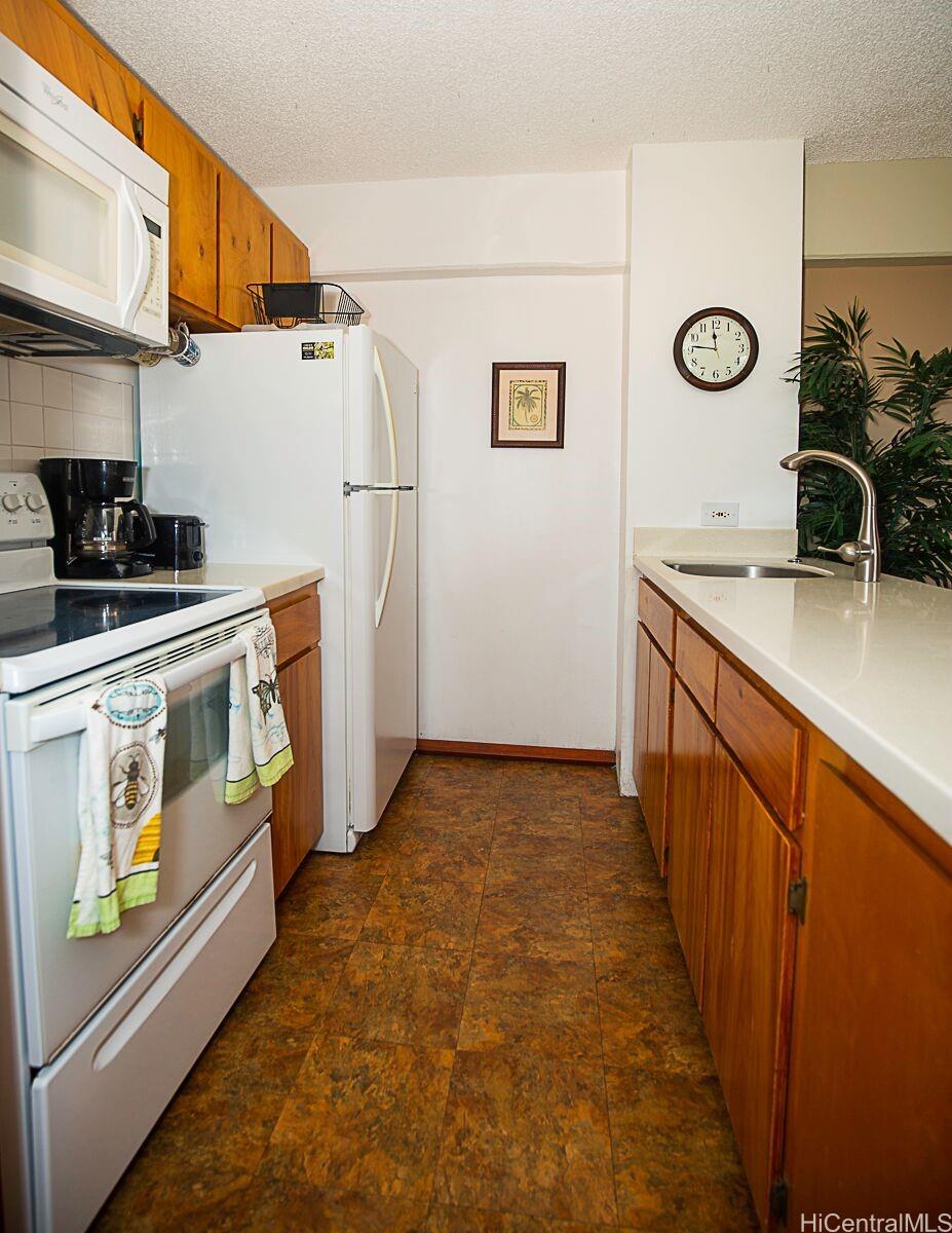 1690 Ala Moana Boulevard, Unit 1105 Honolulu, HI 96815 - Photo 7 of 13 a kitchen with stainless steel appliances granite countertop a stove a refrigerator and a microwave