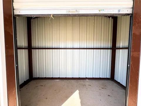 323 Blue Cat Boulevard Haskell, TX 79521 - Photo 14 of 18 Interior storage unit featuring a roll-up door, corrugated metal walls, and a concrete floor
