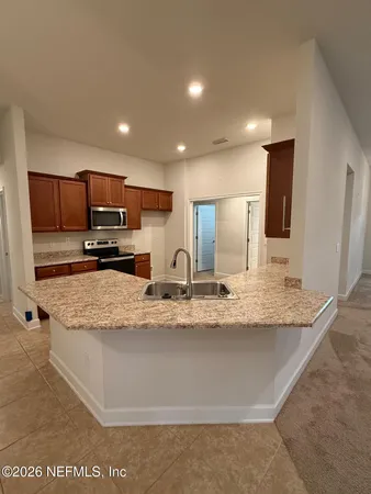 a kitchen with stainless steel appliances granite countertop a sink and a stove top oven with wooden floor