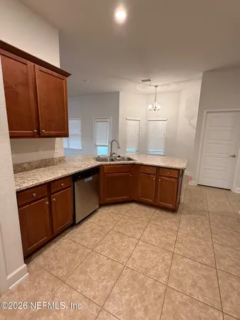 a large kitchen with granite countertop a sink and cabinets