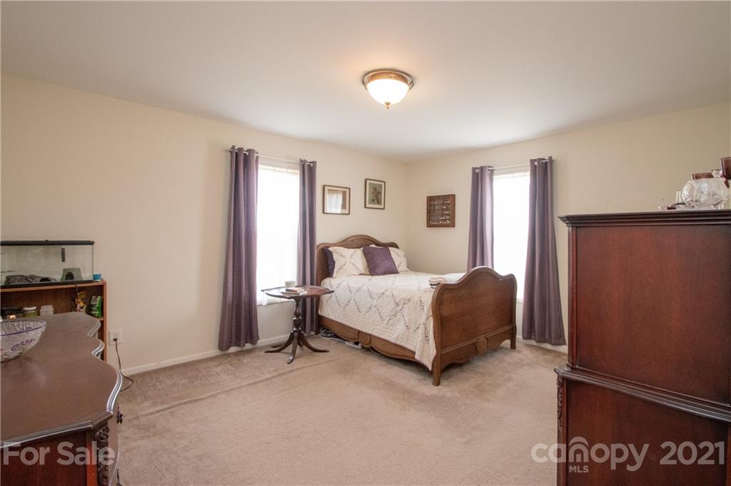 4417 Medlin Road Monroe, NC 28112 - Photo 23 of 30 a bedroom with a bed and a lamp on table