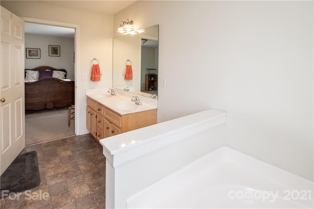 4417 Medlin Road Monroe, NC 28112 - Photo 26 of 30 a en suite bathroom with a sink vanity and mirror