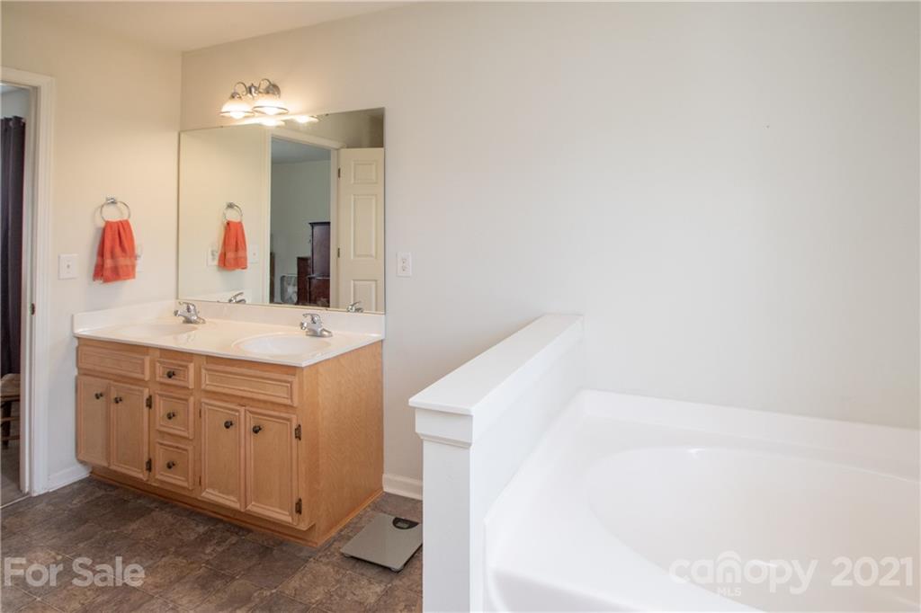 4417 Medlin Road Monroe, NC 28112 - Photo 27 of 30 a bathroom with a bathtub sink and mirror