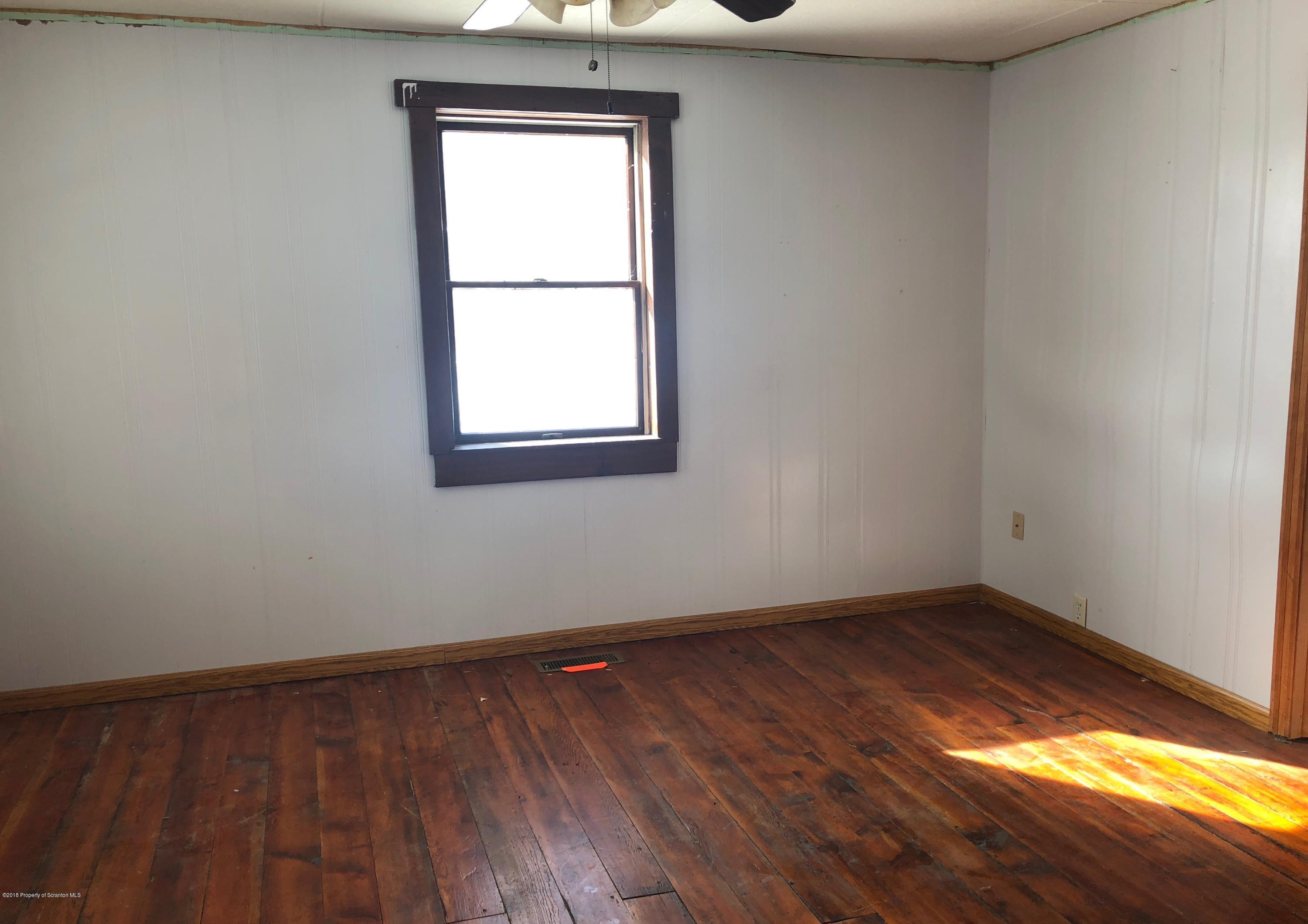 106 Browntown Road Wyalusing, PA 18853 - Photo 3 of 11 an empty room with wooden floor and windows