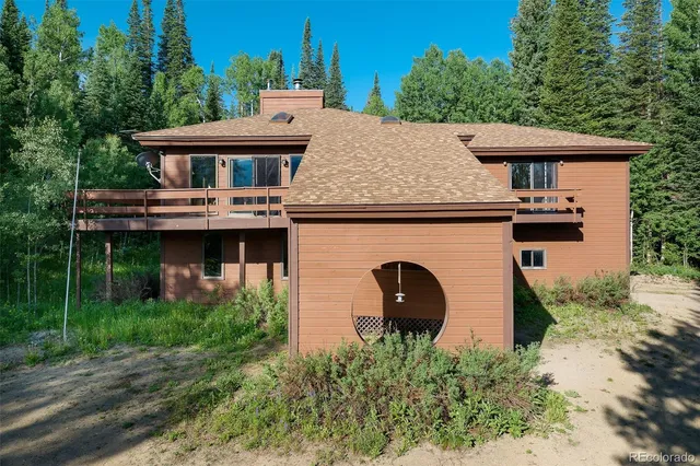 an aerial view of a house with a yard balcony and trees
