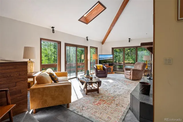 a living room with furniture floor to ceiling window and couch