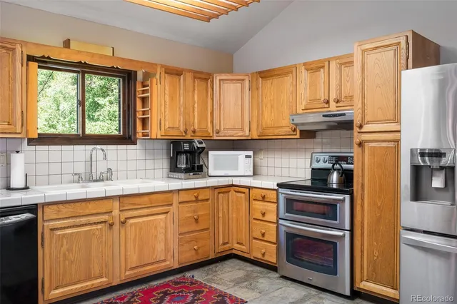 a kitchen with stainless steel appliances granite countertop a refrigerator sink and cabinets