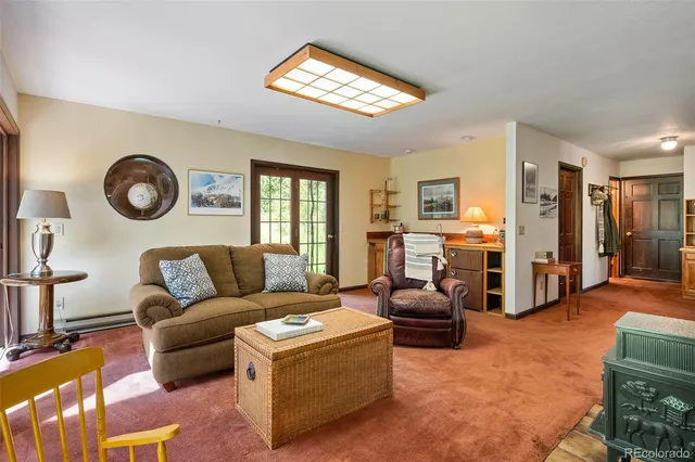 a living room with furniture a clock on wall and a window