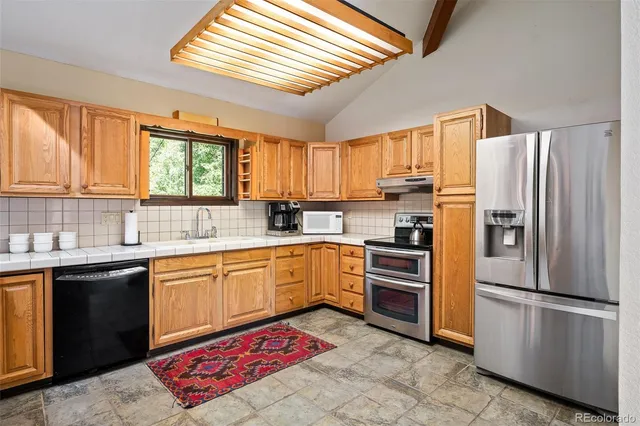a kitchen with stainless steel appliances granite countertop a refrigerator sink and microwave