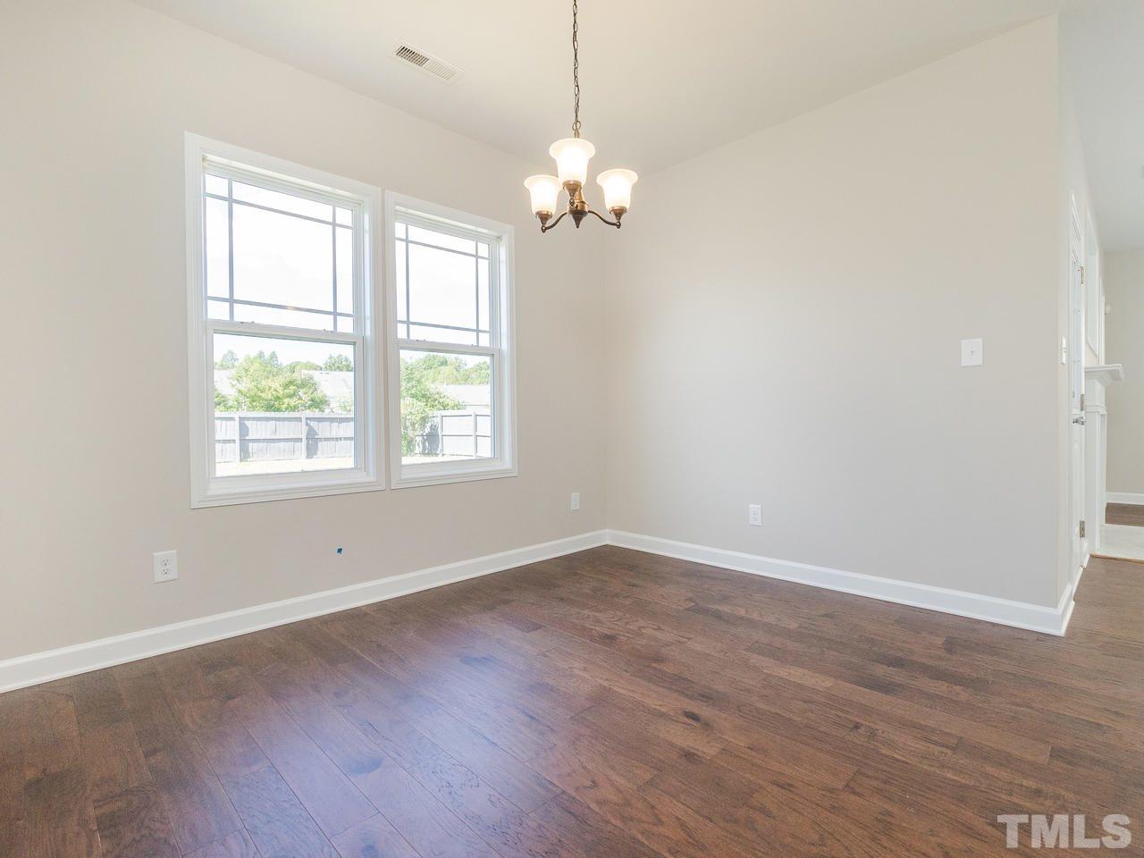 3958 Patriot Ridge Court Raleigh, NC 27610 - Photo 12 of 28 an empty room with wooden floor and windows
