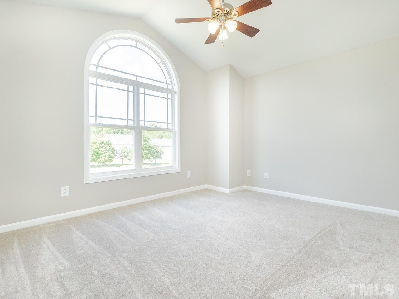 3958 Patriot Ridge Court Raleigh, NC 27610 - Photo 16 of 28 an empty room with windows and chandelier fan
