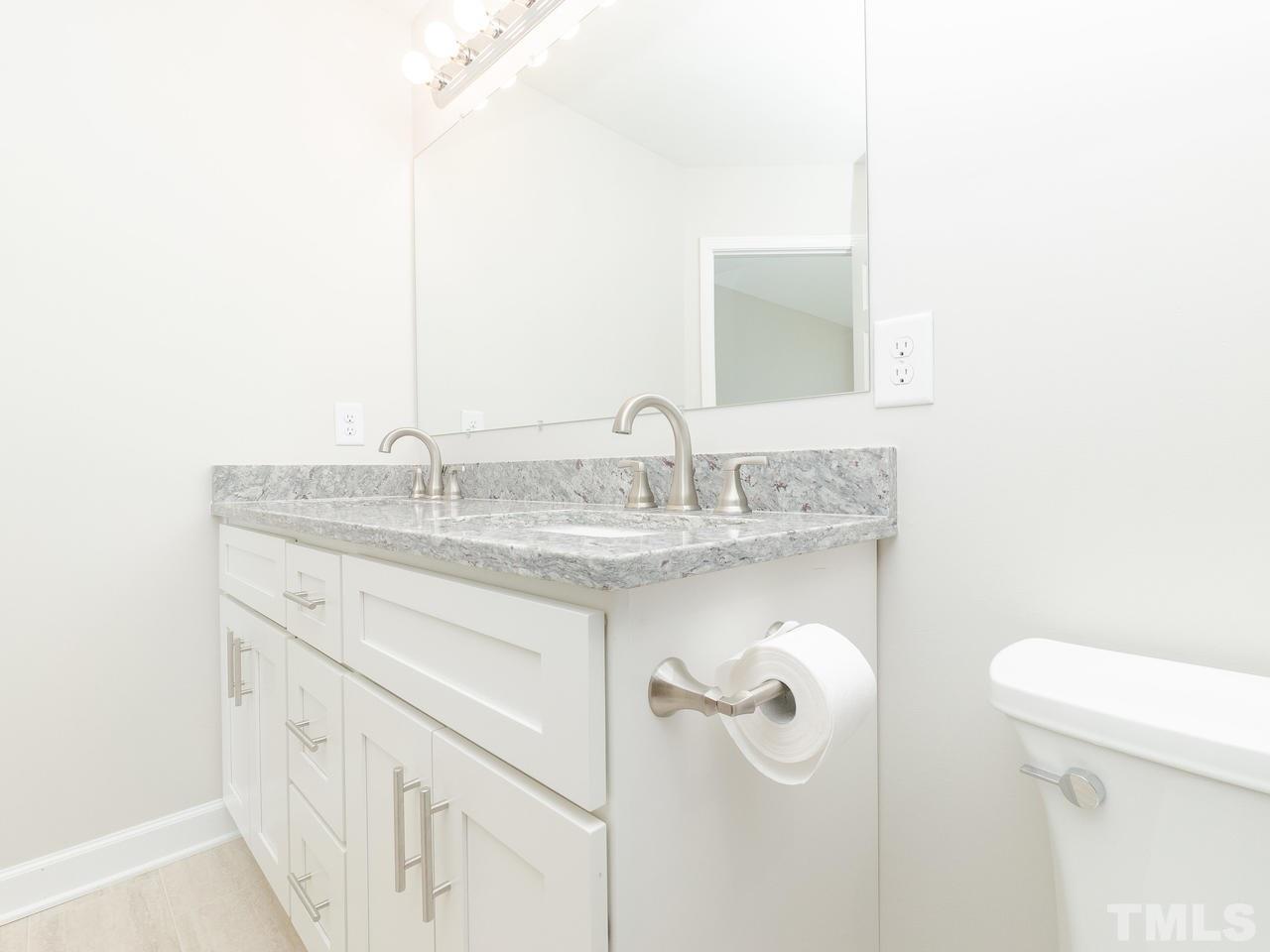 3958 Patriot Ridge Court Raleigh, NC 27610 - Photo 18 of 28 a bathroom with a granite countertop sink and a mirror