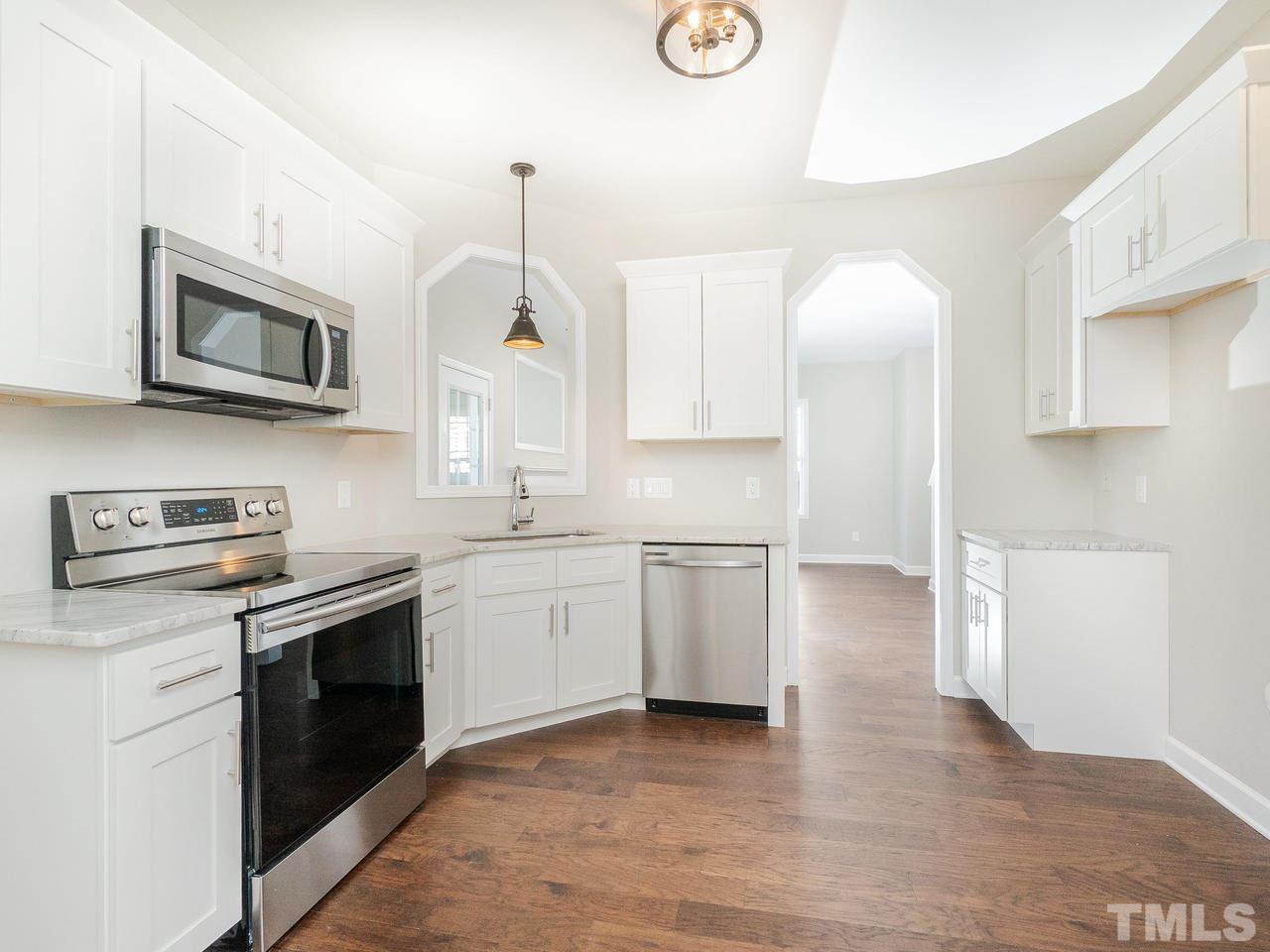 3958 Patriot Ridge Court Raleigh, NC 27610 - Photo 6 of 28 a kitchen with stainless steel appliances granite countertop a stove a sink and a microwave