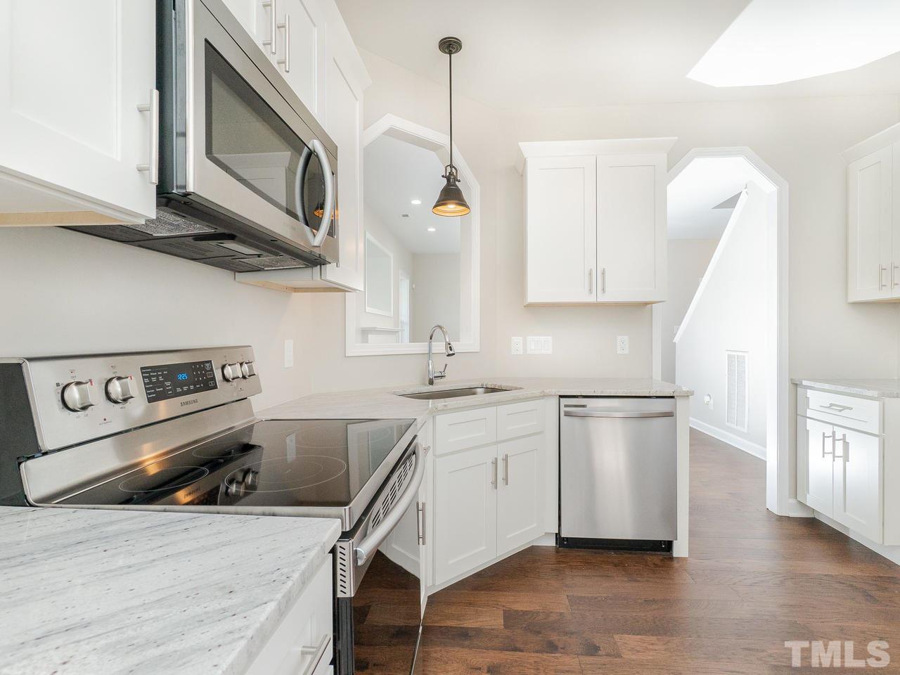 3958 Patriot Ridge Court Raleigh, NC 27610 - Photo 7 of 28 a kitchen with stainless steel appliances granite countertop a sink a stove and a wooden floors