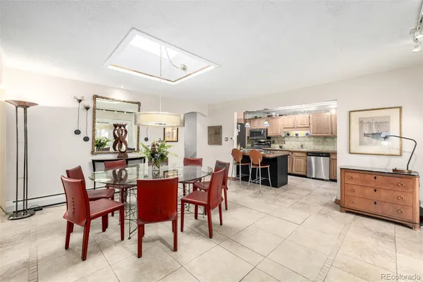 a kitchen with stainless steel appliances kitchen island granite countertop a table and chairs in it