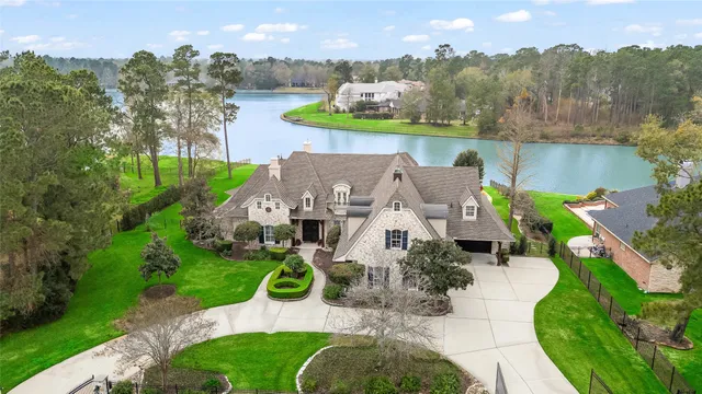 a view of a big house with a big yard and large trees