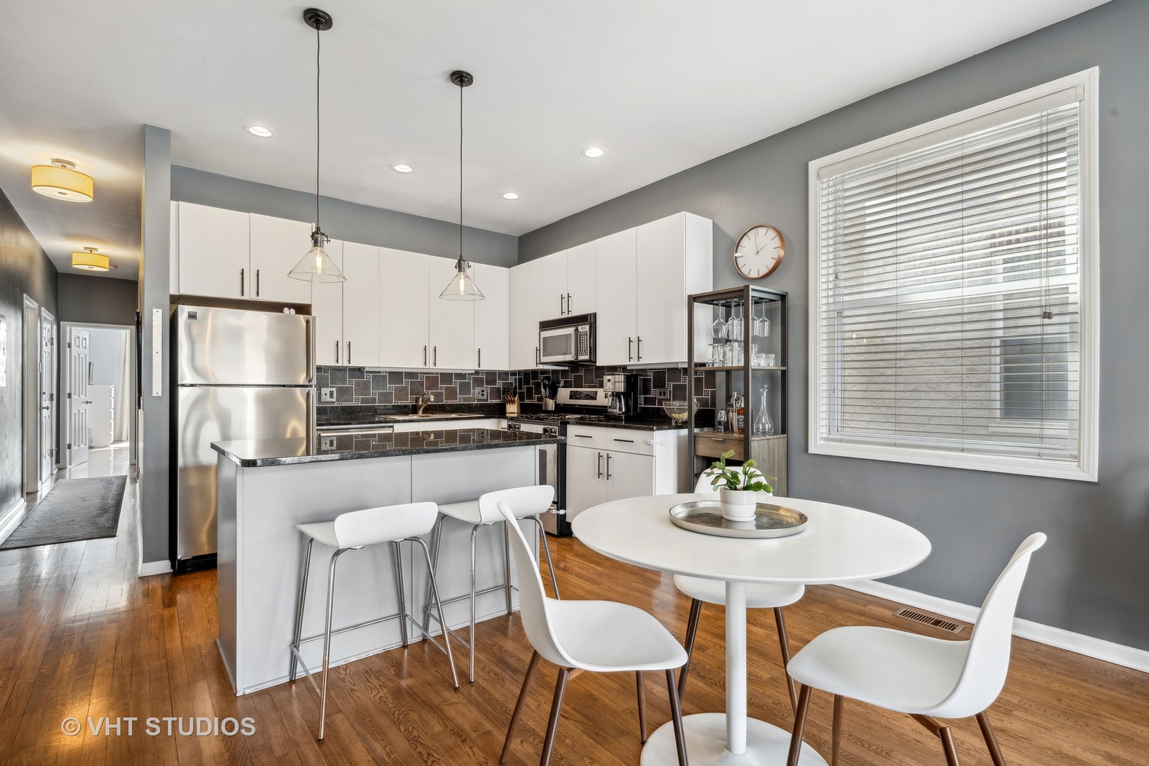 2123 West Rice Street, Unit 3W Chicago, IL 60622 - Photo 7 of 17 a kitchen with a dining table chairs refrigerator and wooden floor