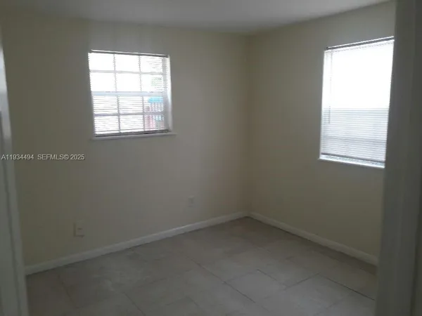 a kitchen with a refrigerator a stove and white cabinets