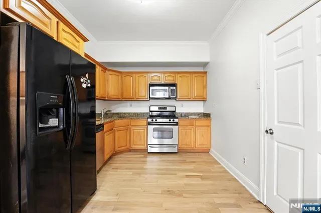 a kitchen with stainless steel appliances granite countertop a refrigerator and a stove top oven