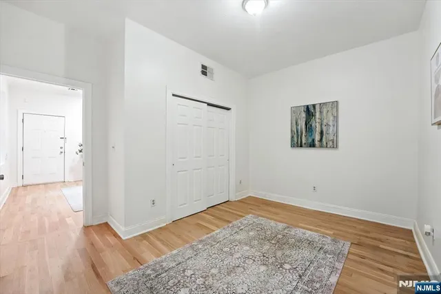 an empty room with wooden floor and closet