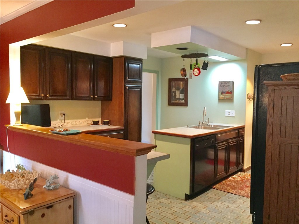 10 Duffield Road Bristol, RI 02809 - Photo 5 of 37 Updated Cherry cabinets with black appliances, built in bar seating that opens to dining and family room.