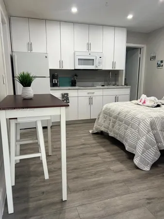 a kitchen with stainless steel appliances kitchen island granite countertop a stove a sink and white cabinets