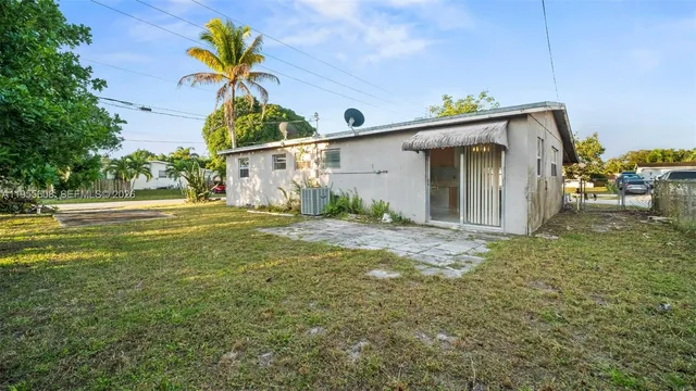 a view of a house with backyard and sitting area