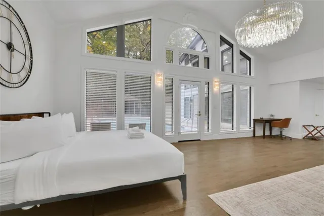 a large white bed sitting in a room next to a window