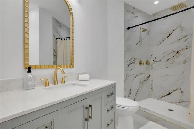 a bathroom with a sink a toilet and a mirror