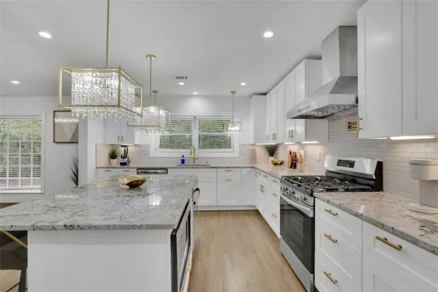 a kitchen with stainless steel appliances granite countertop a stove a sink and a granite counter tops