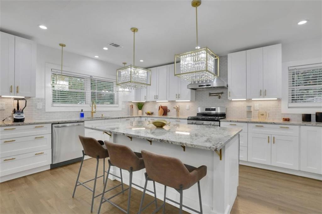 3018 West Pine Valley Road Northwest Atlanta, GA 30305 - Photo 21 of 47 a kitchen with stainless steel appliances a stove a sink a center island and cabinets