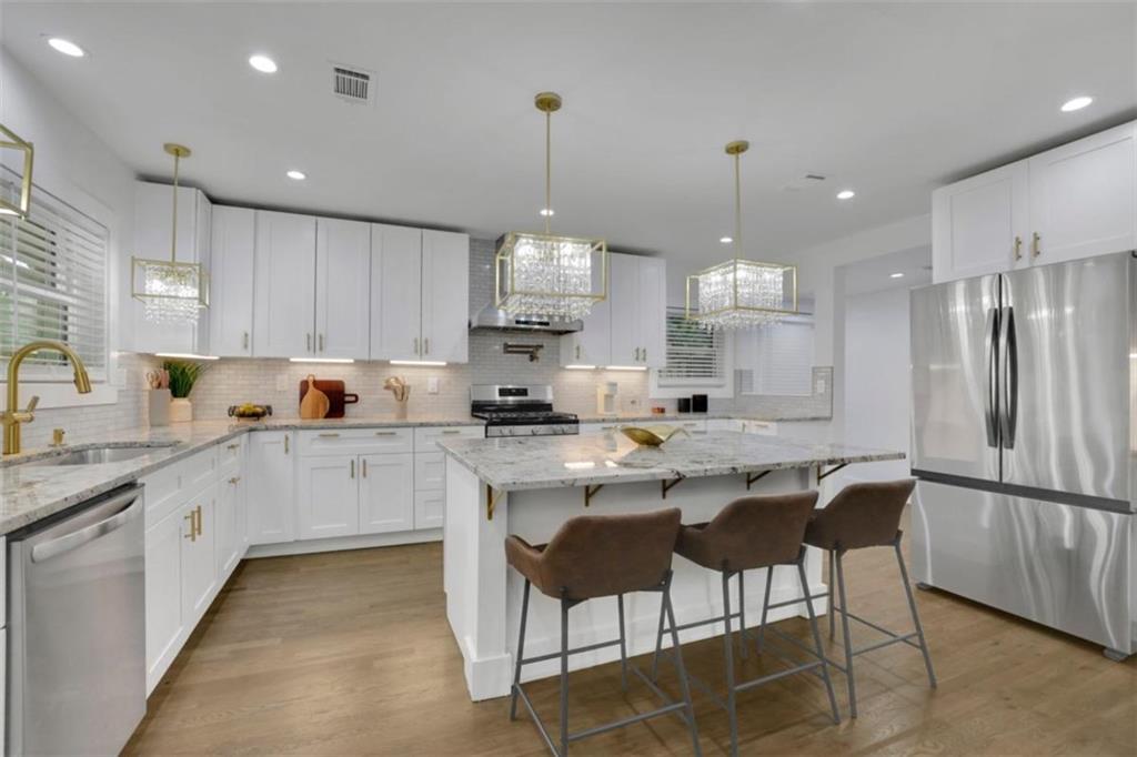 3018 West Pine Valley Road Northwest Atlanta, GA 30305 - Photo 25 of 47 a kitchen with stainless steel appliances granite countertop a sink a stove a refrigerator and island with wooden floor