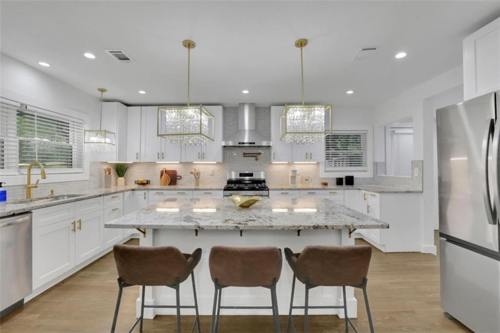 3018 West Pine Valley Road Northwest Atlanta, GA 30305 - Photo 27 of 47 a kitchen with stainless steel appliances granite countertop a stove top oven a refrigerator a sink and chairs