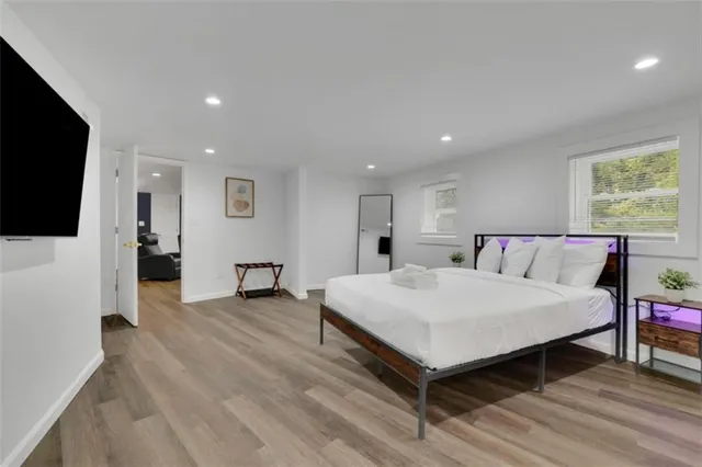 a spacious bedroom with a bed and a flat screen tv