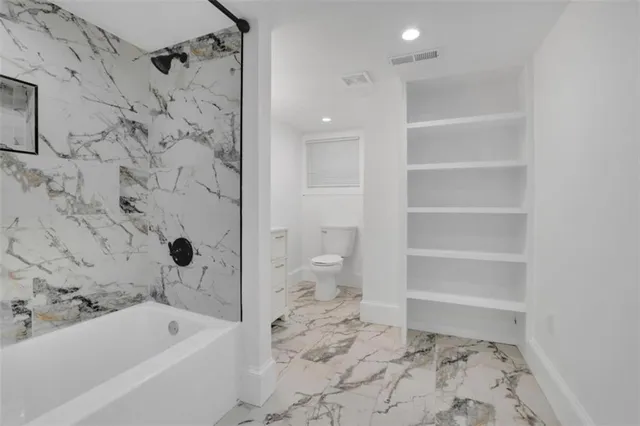 a bathroom with a bathtub and a toilet