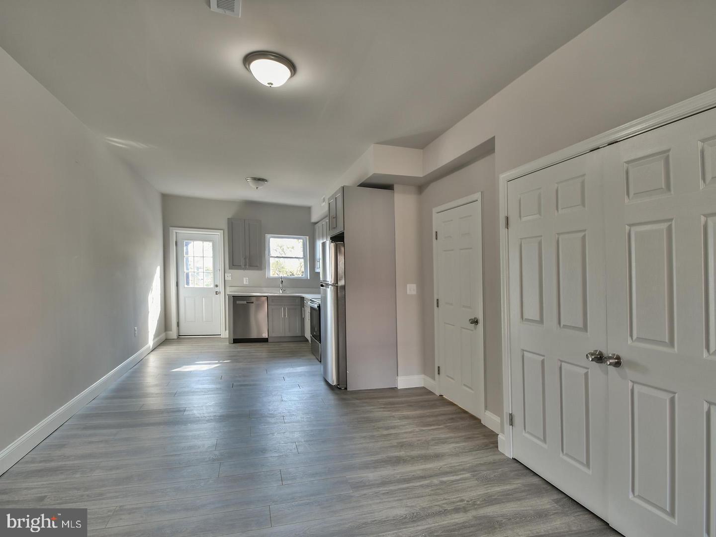 2605 Kirk Avenue Baltimore, MD 21218 - Photo 2 of 17 a view of a kitchen and an empty room with wooden floor