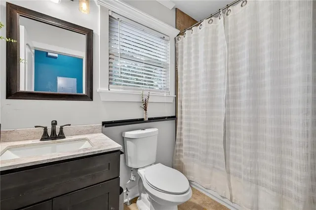 a bathroom with a toilet a sink and a mirror