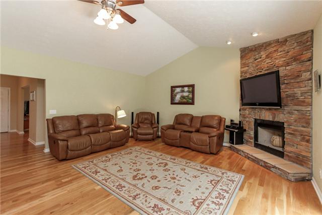 7876 Oscar Green Road Primm Springs, TN 38476 - Photo 7 of 20 Open living room with stone fireplace, recessed lighting, ceiling fan, cathedral ceiling and sliding glass doors that lead to back patio.