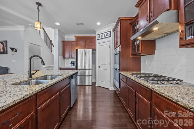 a kitchen with stainless steel appliances granite countertop a refrigerator and a sink
